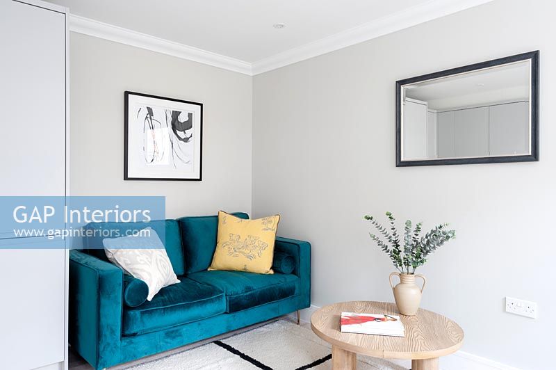 Canapé en velours bleu dans un petit salon moderne