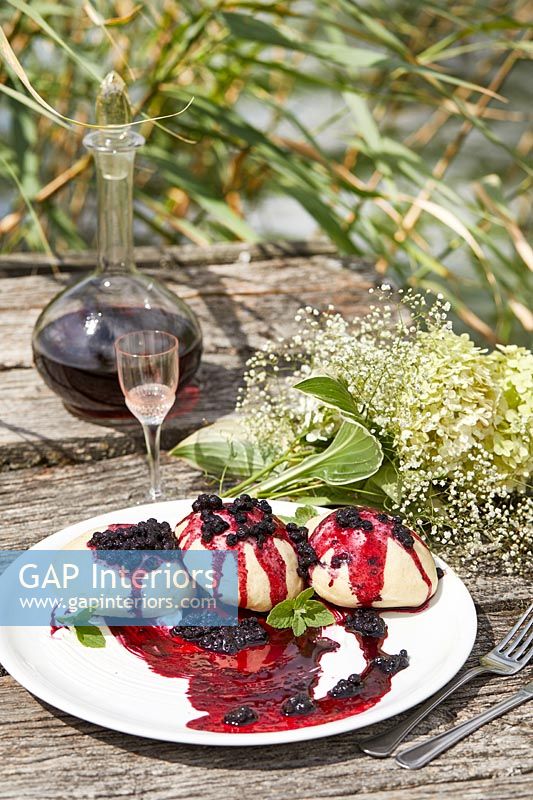 Vin et gâteaux aux fruits des bois sur table de jardin