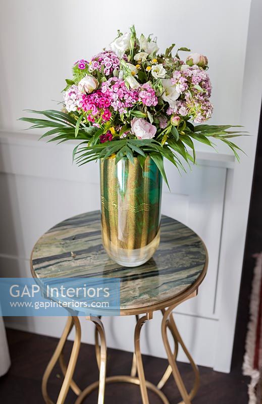 Vase de fleurs sur petite table d'appoint avec plateau en marbre