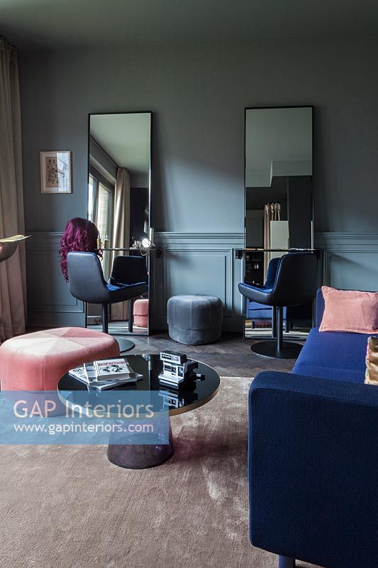Salon moderne avec paire de miroirs et chaises assorties à une extrémité