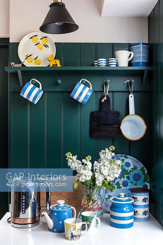 Vaisselle bleu et blanc dans une cuisine moderne avec mur peint en vert