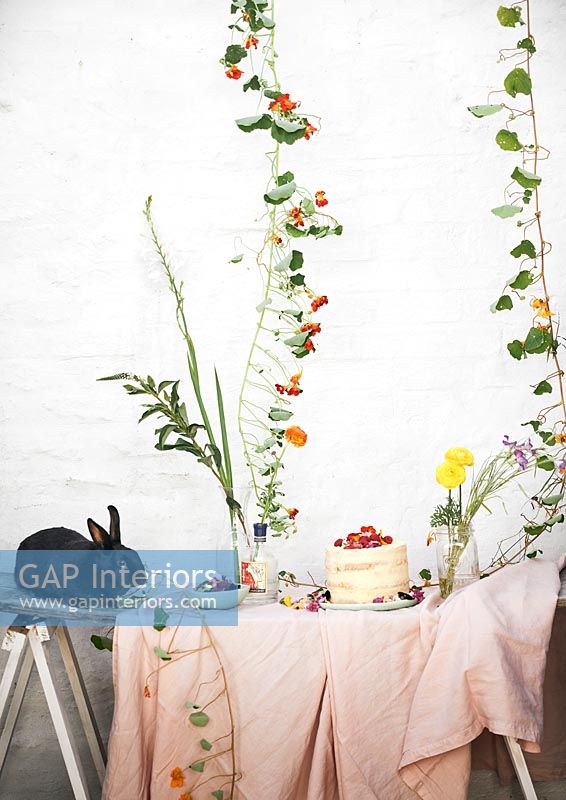 Lapin de compagnie sur table de jardin remplie de fleurs