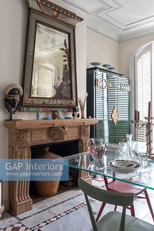 Cheminée en bois sculpté et grand miroir inhabituel dans une salle à manger éclectique