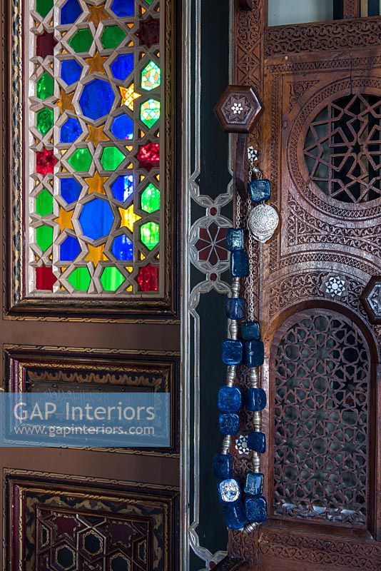 Perles décoratives sur porte en bois ornée avec vitrail coloré