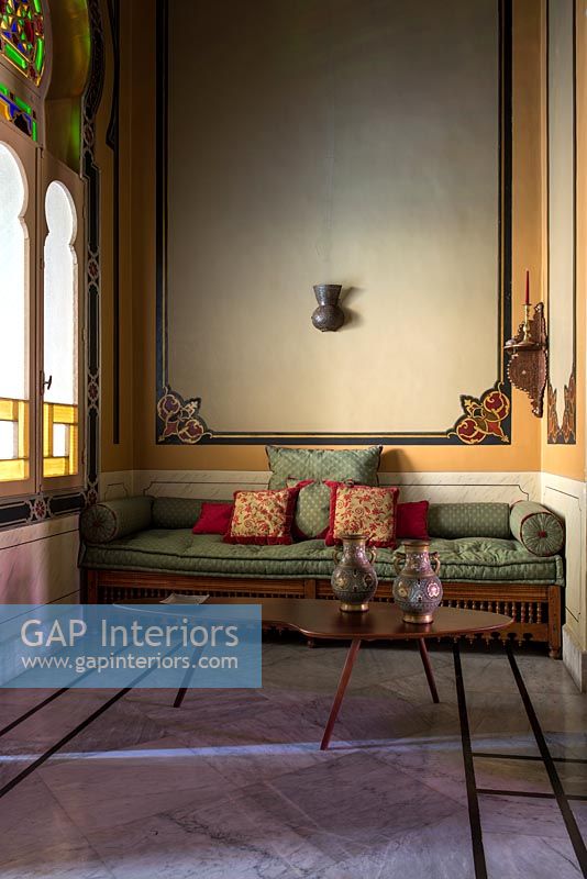 Grand canapé et coussins dans un salon classique avec des murs peints