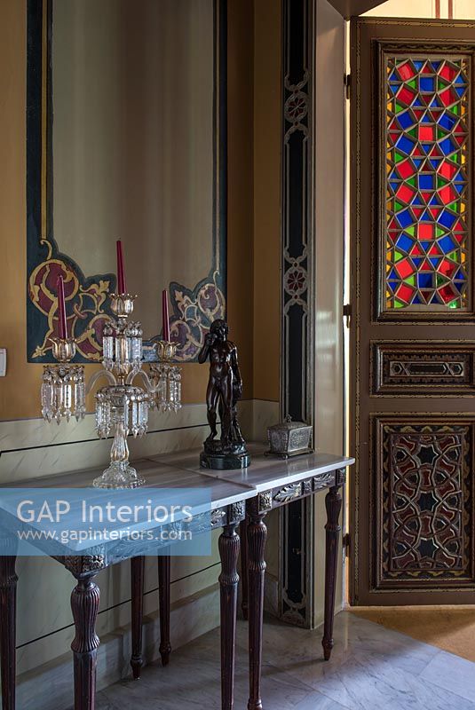 Panneaux muraux peints ornés et table console dans le couloir classique