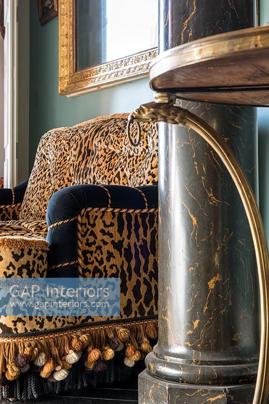 Canapé à imprimé léopard et colonne de marbre dans un salon éclectique