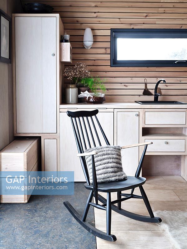 Chaise berçante noire dans la cuisine de campagne moderne en bois
