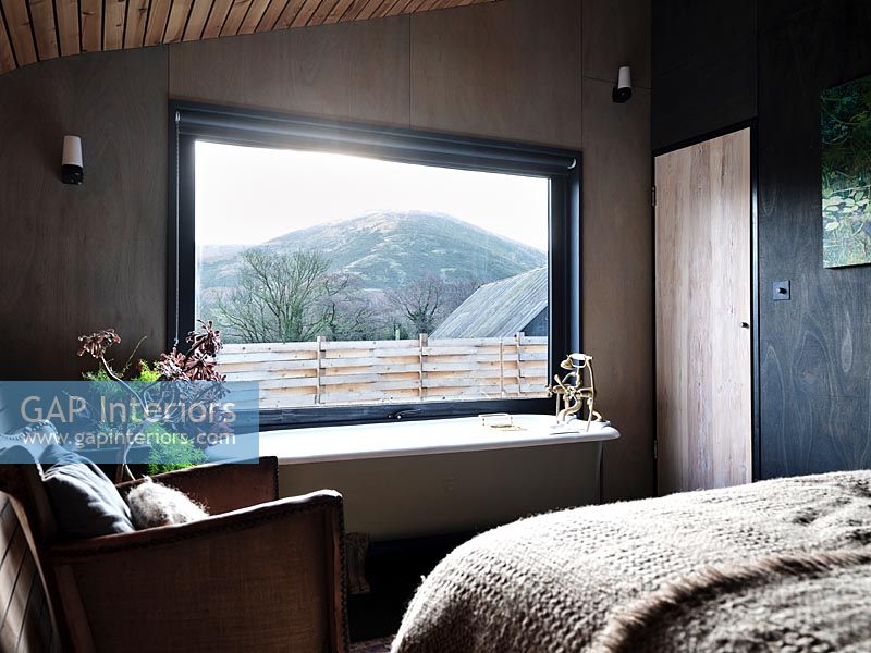 Baignoire à côté de la fenêtre dans une chambre moderne avec vue panoramique
