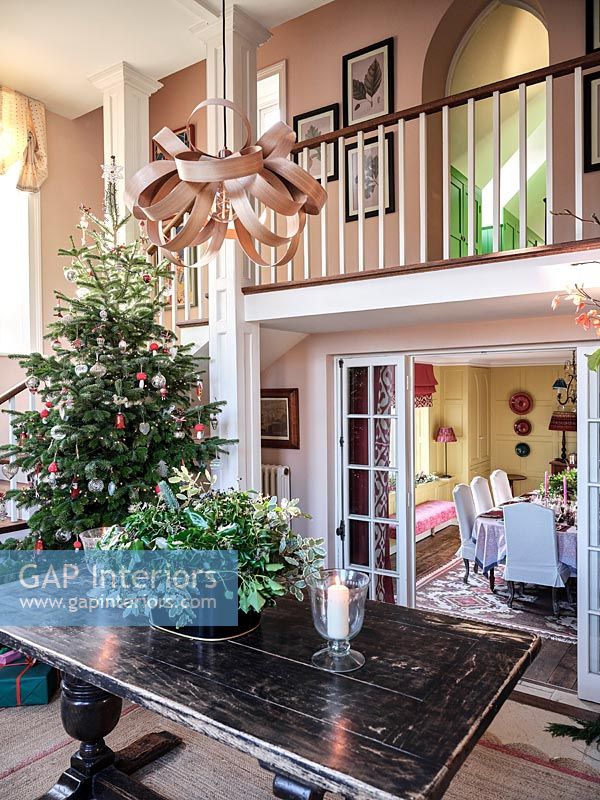 Couloir de style classique avec porte d'entrée ouverte et arbre de Noël