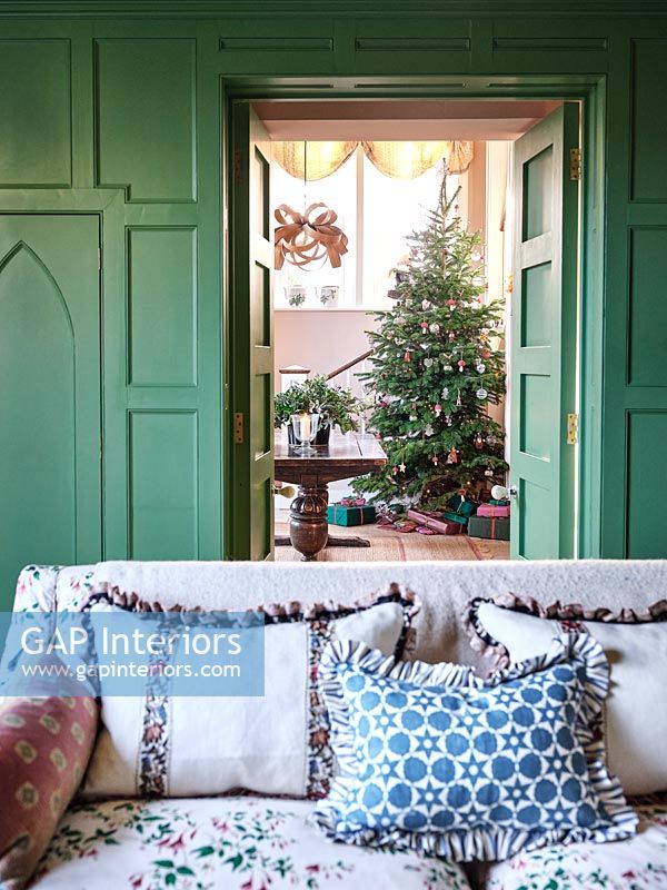 Vue à travers les portes du salon vers le couloir et l'arbre de Noël