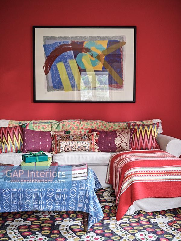 Coussins à motifs sur canapé dans un salon éclectique coloré