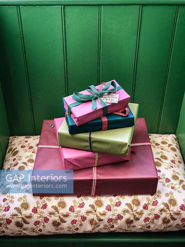 Cadeaux emballés sur petit siège de fenêtre avec mur lambrissé peint en vert
