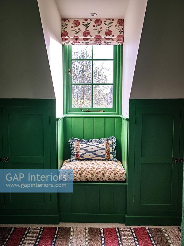 Siège de fenêtre minuscule avec mur lambrissé peint en vert