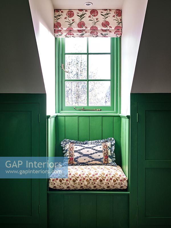 Siège de fenêtre minuscule avec mur lambrissé peint en vert