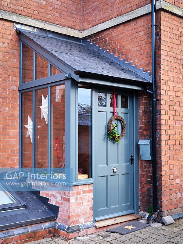 Guirlande de Noël sur l'extérieur de la porte d'entrée peinte en gris