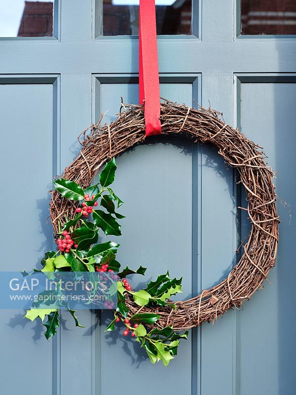 Guirlande de Noël simple sur la porte d'entrée peinte en gris