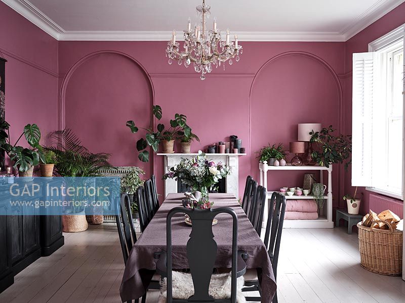 Salle à manger moderne avec des murs peints en rose et des meubles noirs