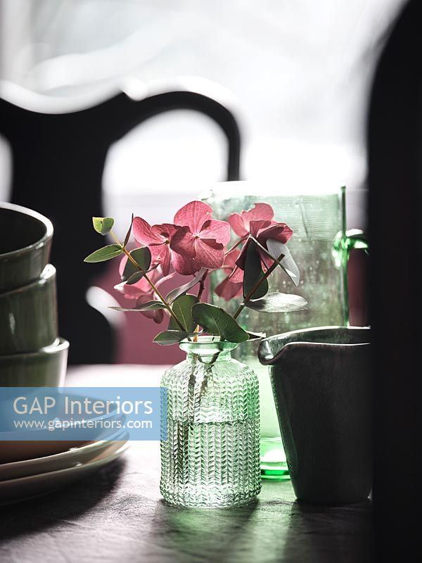 Fleurs d'hortensia rose dans un vase décoratif sur table à manger