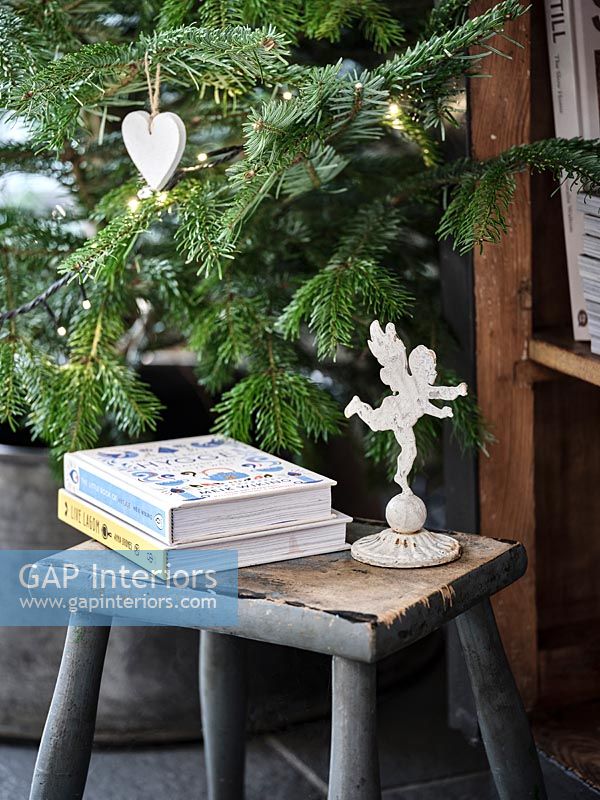 Livres et ornement d'ange à côté de l'arbre de Noël