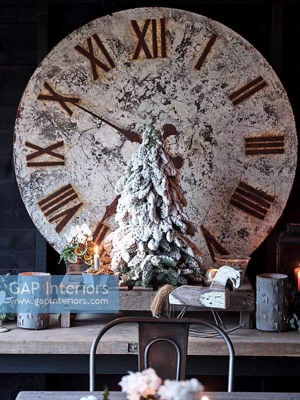 Grande horloge, décorations de Noël et bougies sur table en bois