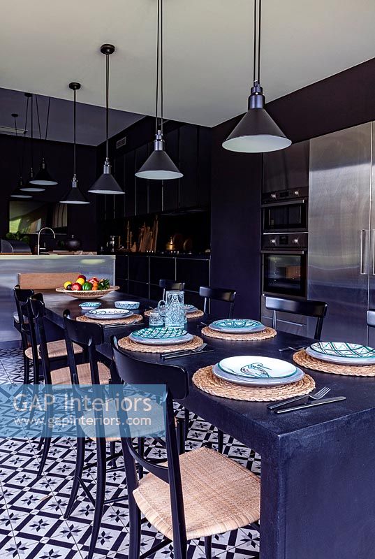 Grande table à manger noire dans la cuisine-salle à manger moderne