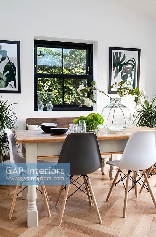 Table à manger moderne et chaises avec fenêtre encadrée noire