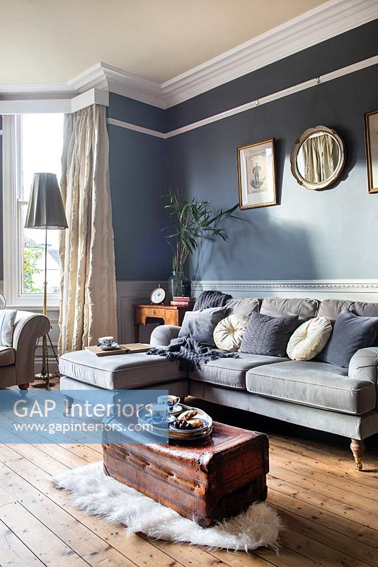 Murs peints en gris foncé et éléments d'origine dans un salon moderne