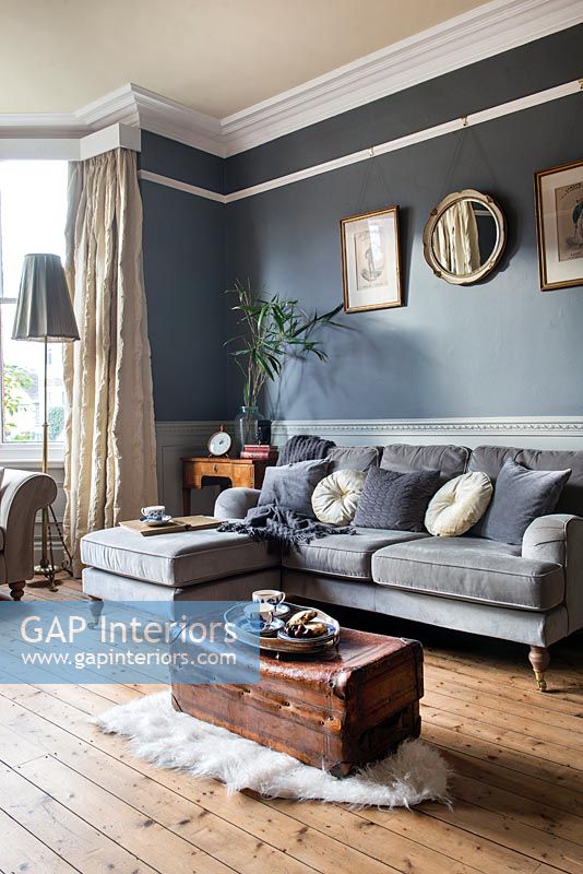 Murs peints en gris foncé et éléments d'origine dans un salon moderne