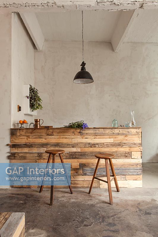 Comptoir de cuisine moderne et tabourets de bar en bois de récupération