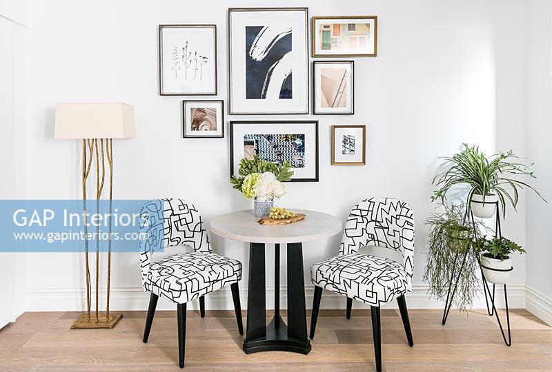 Table et chaises modernes avec affichage d'œuvres d'art encadrées sur le mur