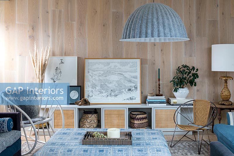 Salon avec murs en planches de bois et décoration sur le thème bleu