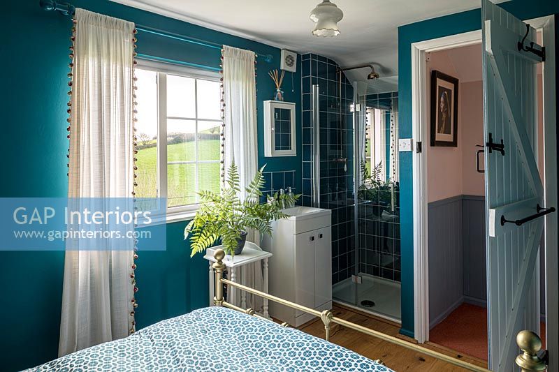 Chambre de campagne colorée avec lit en laiton et cabine de douche
