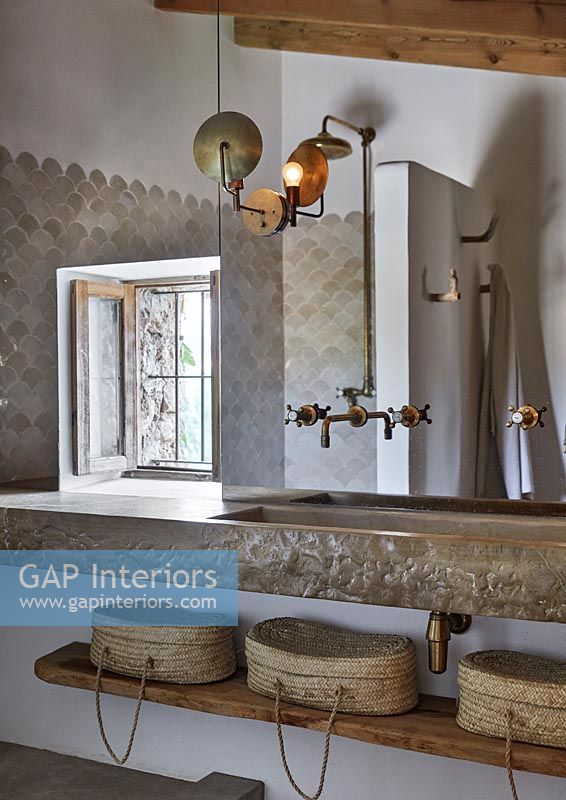 Grand lavabo en pierre et miroir dans la salle de bains de pays moderne