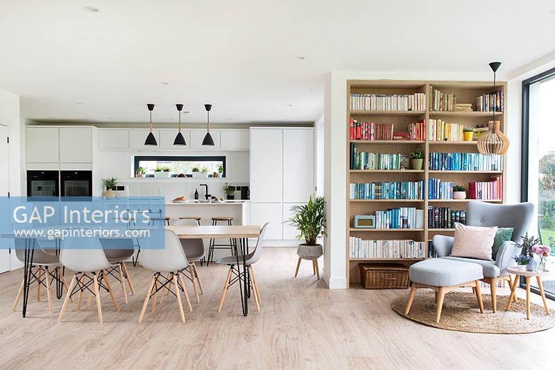 Cuisine-salle à manger moderne avec étagères et chaise de lecture dans le coin