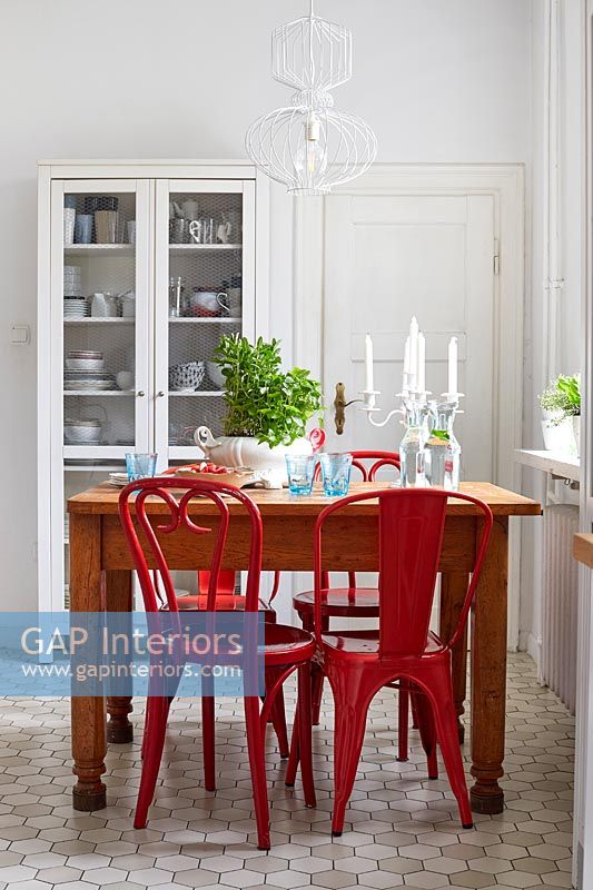Chaises rouges autour d'une petite table en bois dans la cuisine-salle à manger