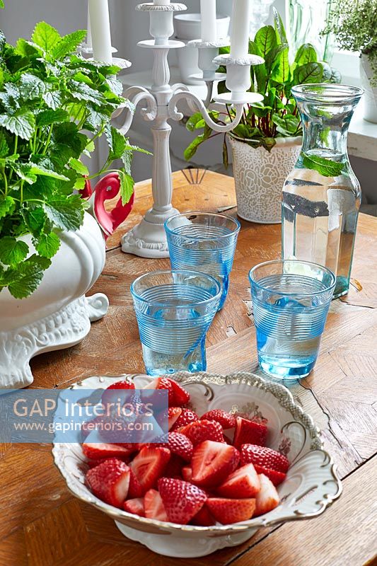 Bol de fraises et verres d'eau sur table en bois