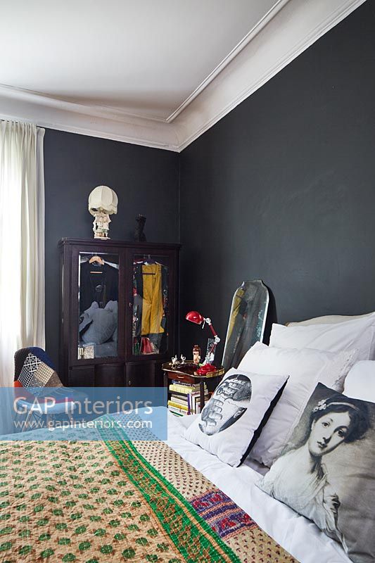 Couvre-lit rose et vert dans la chambre aux murs peints en noir