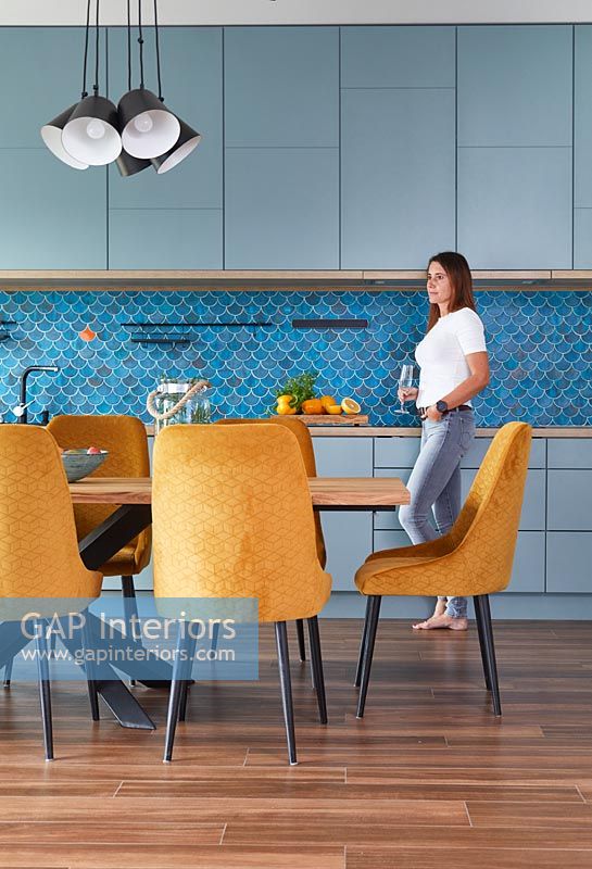 Appartement décloisonné aux couleurs vives avec influence du Moyen-Orient avec femme dans la cuisine