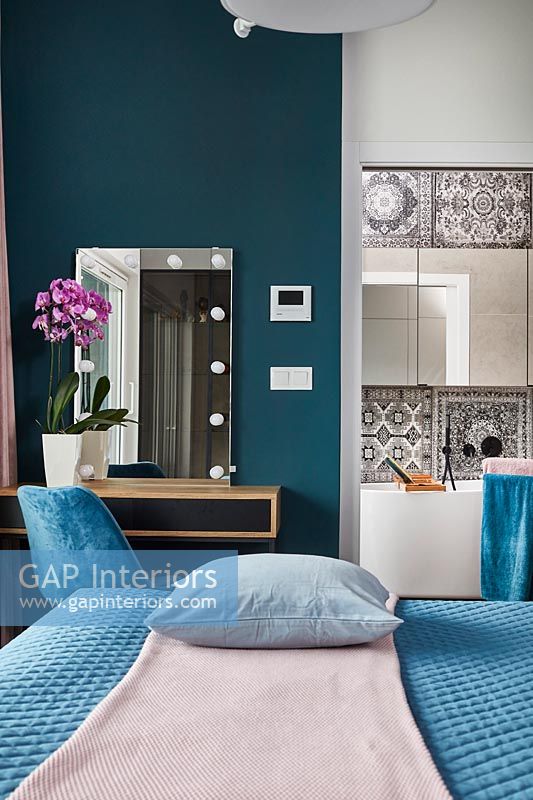 Chambre dans l'appartement avec vue sur salle de bains avec miroir et coiffeuse