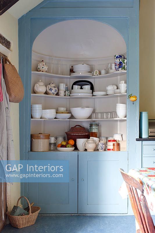 Armoire peinte en bleu avec étagères dans la cuisine-salle à manger de campagne