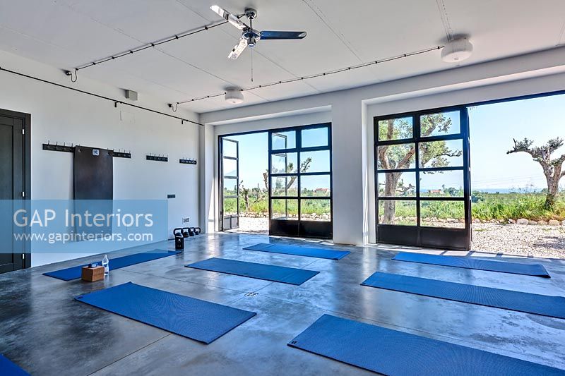 Studio de yoga avec portes ouvertes sur des vues panoramiques sur le paysage au-delà