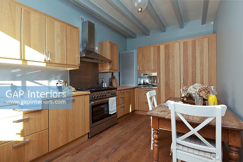 Cuisine-salle à manger en bois moderne avec murs peints en bleu pâle