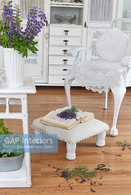 Meubles blancs dans le salon de campagne avec des fleurs coupées