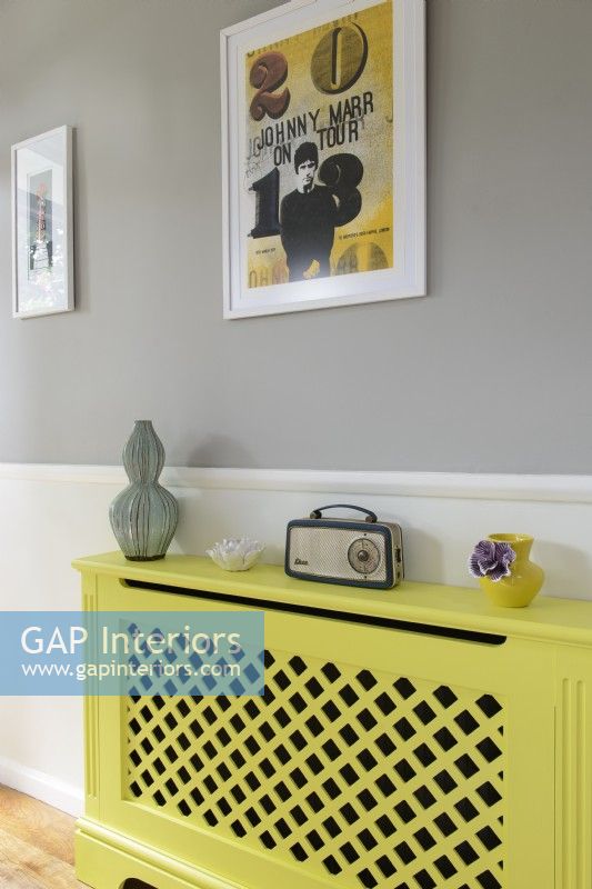 Radio vintage sur couvercle de radiateur peint en jaune dans le couloir moderne