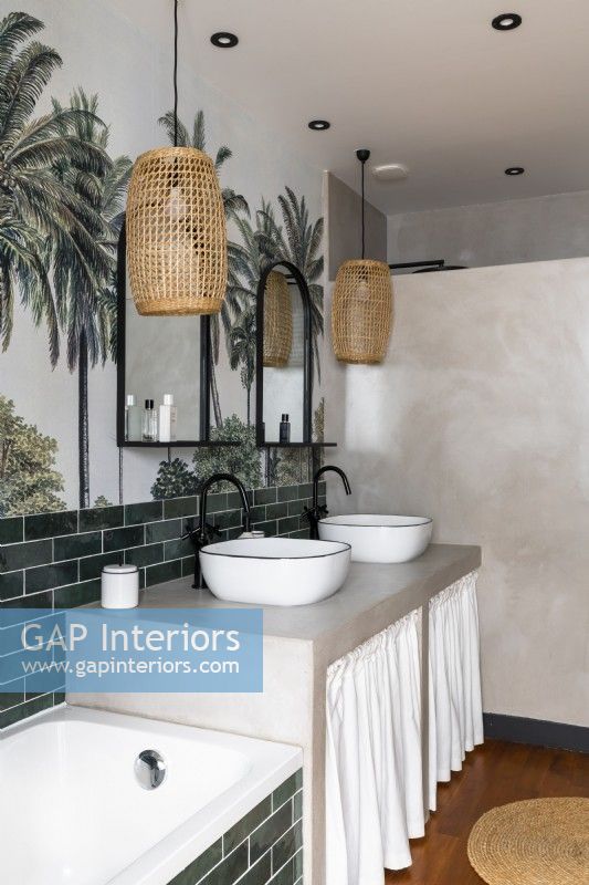 Jupes sous deux lavabos dans une salle de bains moderne avec une fresque murale tropicale