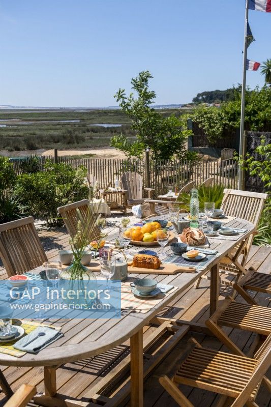 Table à manger extérieure prévue pour le déjeuner avec vue sur la côte en été
