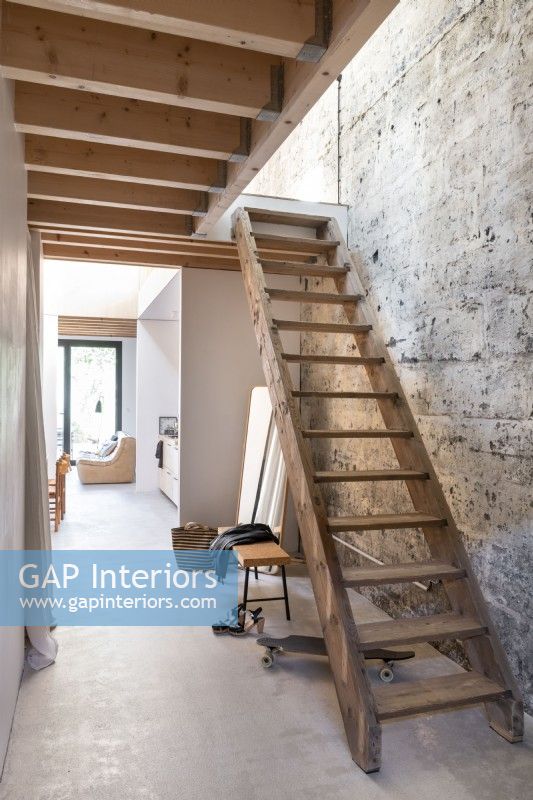 Escalier en bois dans le couloir moderne avec mur de plâtre nu