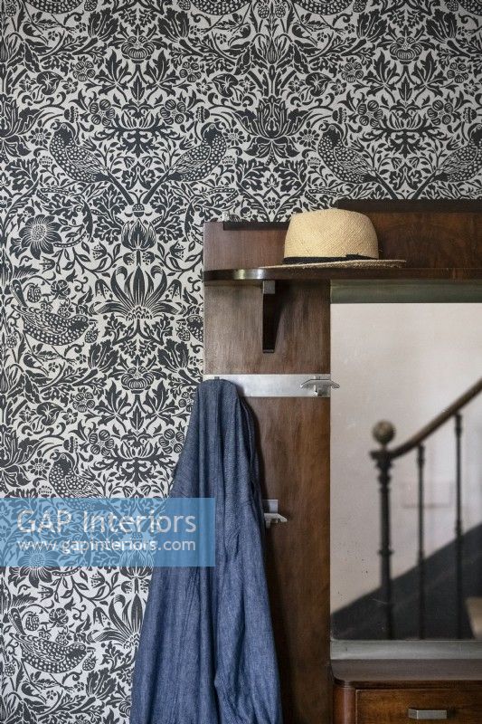 Porte-manteau et chapeau dans le couloir avec papier peint décoratif - détail