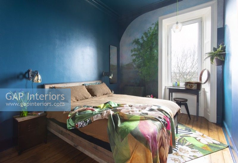 Chambre à coucher moderne colorée avec la peinture murale peinte autour de la fenêtre